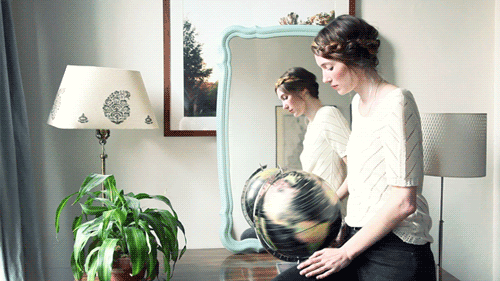 Animated gif of woman spinning an Earth globe on the table Motion photogram, photorealistic animated gif image