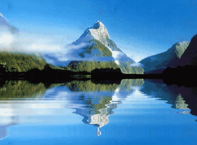 Serene lake scene with snow covered mountain reflecting in the rippling waves