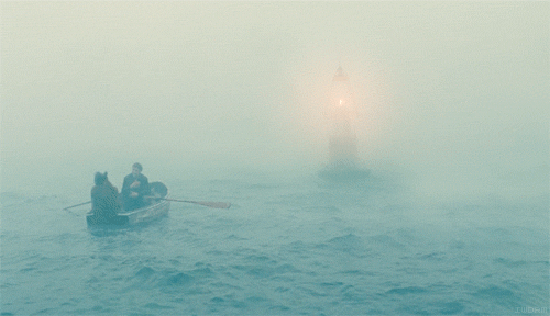 Two guys sitting in a row boat near a flashing marker buoy in a thick fog bank on the ocean